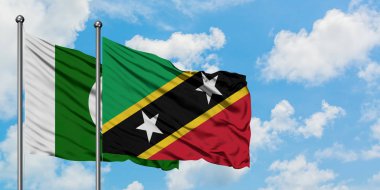 Pakistan ve Saint Kitts ve Nevis bayrağı birlikte beyaz bulutlu mavi gökyüzüne karşı rüzgarda sallayarak. Diplomasi kavramı, uluslararası ilişkiler.
