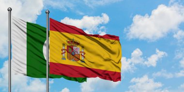 Pakistan ve İspanya bayrağı birlikte beyaz bulutlu mavi gökyüzüne karşı rüzgarsal sallayarak. Diplomasi kavramı, uluslararası ilişkiler.