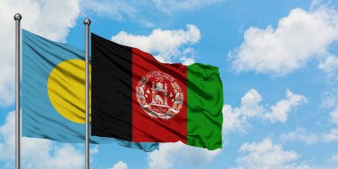 Palau ve Afganistan bayrağı birlikte beyaz bulutlu mavi gökyüzüne karşı rüzgarda sallayarak. Diplomasi kavramı, uluslararası ilişkiler.