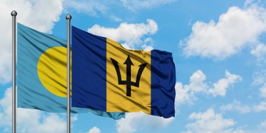 Palau ve Barbados bayrağı birlikte beyaz bulutlu mavi gökyüzüne karşı rüzgarda sallayarak. Diplomasi kavramı, uluslararası ilişkiler.
