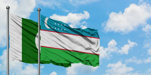 Paquistão e Uzbequistão acenando com o vento contra o céu azul nublado branco juntos. Conceito de diplomacia, relações internacionais . — Fotografia de Stock