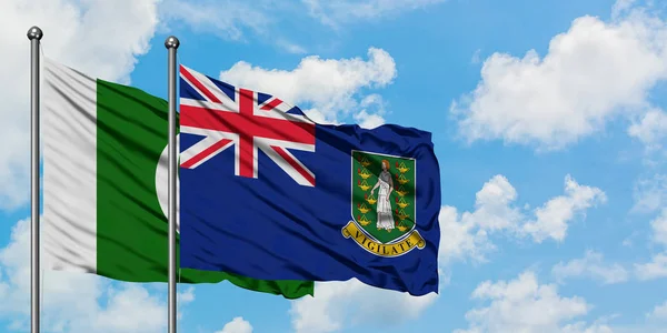 Bandera de Pakistán y las Islas Vírgenes Británicas ondeando en el viento contra el cielo azul nublado blanco juntos. Concepto diplomático, relaciones internacionales . — Foto de Stock