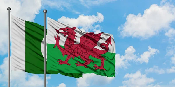 Pakistan en Wales vlag zwaaien in de wind tegen witte bewolkte blauwe hemel samen. Diplomatie concept, internationale betrekkingen. — Stockfoto