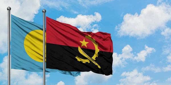 Palau och Angola sjunker vifta i vinden mot vit grumlig blå himmel tillsammans. Diplomatisk koncept, internationella relationer. — Stockfoto