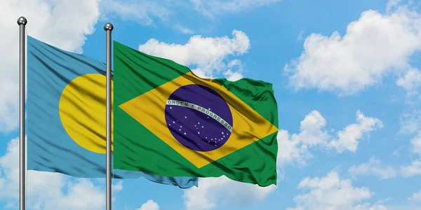 Palau e a bandeira do Brasil agitando no vento contra o céu azul nublado branco juntos. Conceito de diplomacia, relações internacionais . — Fotografia de Stock