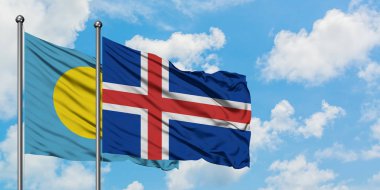 Palau ve İzlanda bayrağı birlikte beyaz bulutlu mavi gökyüzüne karşı rüzgarda sallayarak. Diplomasi kavramı, uluslararası ilişkiler.