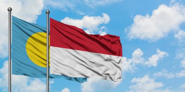 Palau ve Endonezya bayrağı birlikte beyaz bulutlu mavi gökyüzüne karşı rüzgarda sallayarak. Diplomasi kavramı, uluslararası ilişkiler.