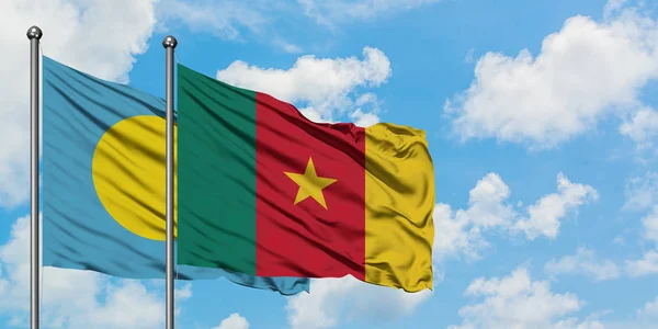 Bandera de Palaos y Camerún ondeando en el viento contra el cielo azul nublado blanco juntos. Concepto diplomático, relaciones internacionales . — Foto de Stock