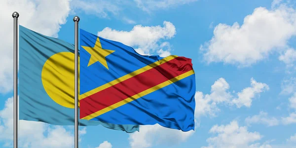 Bandera de Palaos y Congo ondeando en el viento contra el cielo azul nublado blanco juntos. Concepto diplomático, relaciones internacionales . — Foto de Stock