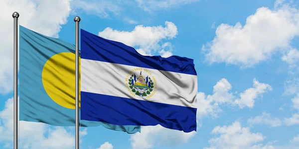 Bandera de Palaos y El Salvador ondeando en el viento contra el cielo azul nublado blanco juntos. Concepto diplomático, relaciones internacionales . — Foto de Stock