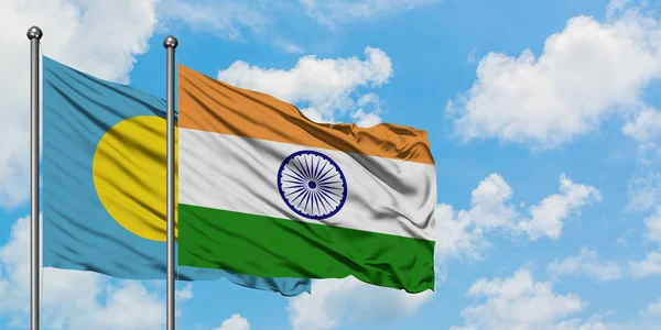 Palau i Indie flaga machając w wiatr przed białym zachmurzone błękitne niebo razem. Koncepcja dyplomacji, stosunki międzynarodowe. — Zdjęcie stockowe