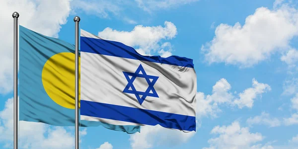 Bandera de Palaos e Israel ondeando en el viento contra el cielo azul nublado blanco juntos. Concepto diplomático, relaciones internacionales . — Foto de Stock