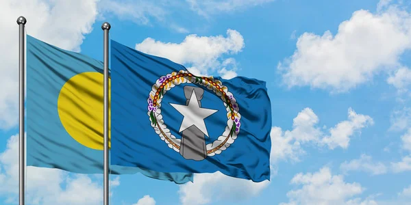 Bandera de Palaos e Islas Marianas del Norte ondeando en el viento contra el cielo azul nublado blanco juntos. Concepto diplomático, relaciones internacionales . — Foto de Stock