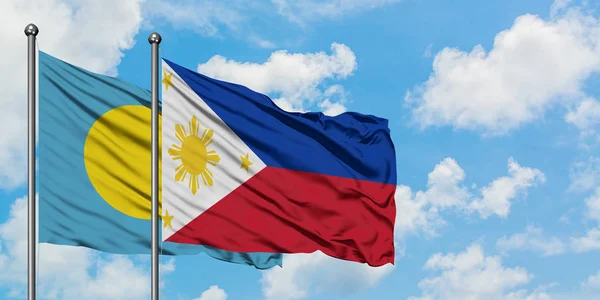 Bandera de Palaos y Filipinas ondeando en el viento contra el cielo azul nublado blanco juntos. Concepto diplomático, relaciones internacionales . — Foto de Stock