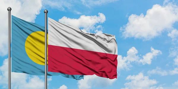 Bandera de Palaos y Polonia ondeando en el viento contra el cielo azul nublado blanco juntos. Concepto diplomático, relaciones internacionales . — Foto de Stock