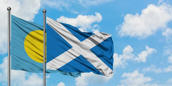 Palau and Scotland flag waving in the wind against white cloudy blue sky together. Diplomacy concept, international relations.