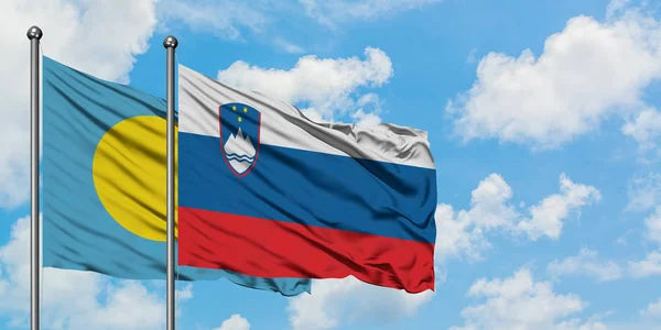 Palau and Slovenia flag waving in the wind against white cloudy blue sky together. Diplomacy concept, international relations.