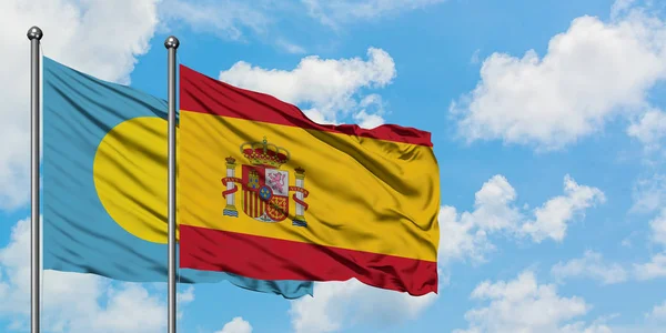 Bandera de Palaos y España ondeando en el viento contra el cielo azul nublado blanco juntos. Concepto diplomático, relaciones internacionales . — Foto de Stock