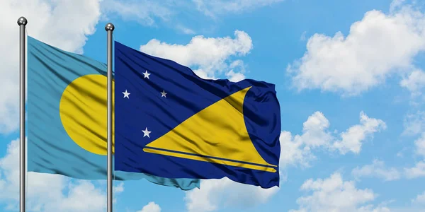 Bandera de Palau y Tokelau ondeando en el viento contra el cielo azul nublado blanco juntos. Concepto diplomático, relaciones internacionales . — Foto de Stock