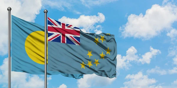 Bandera de Palau y Tuvalu ondeando en el viento contra el cielo azul nublado blanco juntos. Concepto diplomático, relaciones internacionales . — Foto de Stock