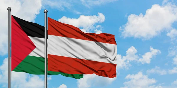 Bandera de Palestina y Austria ondeando en el viento contra el cielo azul nublado blanco juntos. Concepto diplomático, relaciones internacionales . — Foto de Stock