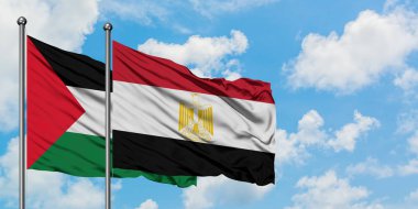 Filistin ve Mısır bayrağı birlikte beyaz bulutlu mavi gökyüzüne karşı rüzgarda sallayarak. Diplomasi kavramı, uluslararası ilişkiler.