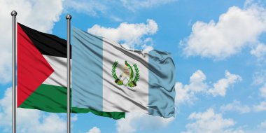 Filistin ve Guatemala bayrağı birlikte beyaz bulutlu mavi gökyüzüne karşı rüzgarda sallayarak. Diplomasi kavramı, uluslararası ilişkiler.