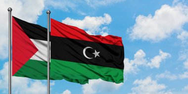 Filistin ve Libya bayrağı birlikte beyaz bulutlu mavi gökyüzüne karşı rüzgarsal sallayarak. Diplomasi kavramı, uluslararası ilişkiler.