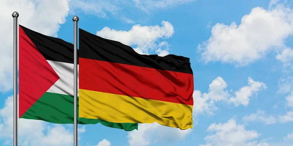 Bandera de Palestina y Alemania ondeando en el viento contra el cielo azul nublado blanco juntos. Concepto diplomático, relaciones internacionales . — Foto de Stock