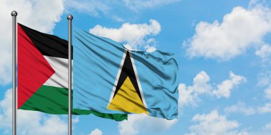 Filistin ve Saint Lucia bayrağı birlikte beyaz bulutlu mavi gökyüzüne karşı rüzgarda sallayarak. Diplomasi kavramı, uluslararası ilişkiler.