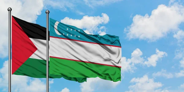 Drapeau de Palestine et d'Ouzbékistan agitant dans le vent contre le ciel bleu nuageux blanc ensemble. Concept de diplomatie, relations internationales . — Photo