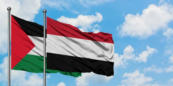 Bandera de Palestina y Yemen ondeando en el viento contra el cielo azul nublado blanco juntos. Concepto diplomático, relaciones internacionales . — Foto de Stock