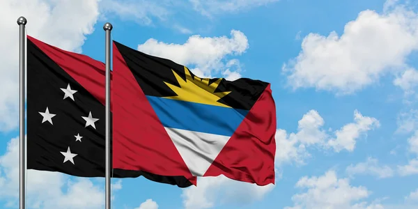 Papouasie-Nouvelle-Guinée et Antigua-et-Barbuda drapeau agitant dans le vent contre ciel bleu nuageux blanc ensemble. Concept de diplomatie, relations internationales . — Photo