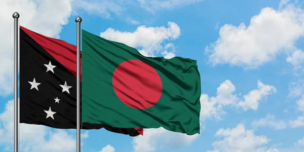 Bandera de Papúa Nueva Guinea y Bangladesh ondeando en el viento contra el cielo azul nublado blanco juntos. Concepto diplomático, relaciones internacionales . — Foto de Stock