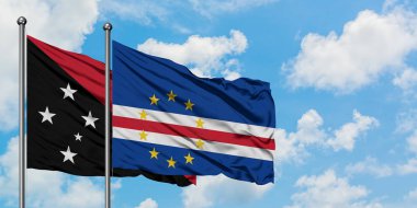 Papua Yeni Gine ve Cape Verde bayrağı birlikte beyaz bulutlu mavi gökyüzüne karşı rüzgarda sallayarak. Diplomasi kavramı, uluslararası ilişkiler.