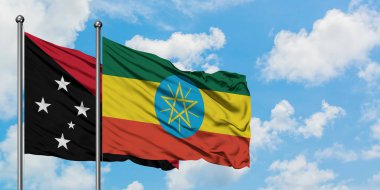 Papua Yeni Gine ve Etiyopya bayrağı birlikte beyaz bulutlu mavi gökyüzüne karşı rüzgarsal sallayarak. Diplomasi kavramı, uluslararası ilişkiler.