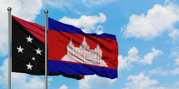 Papua Nya Guinea och Kambodja flagga vinka i vinden mot vit grumlig blå himmel tillsammans. Diplomatisk koncept, internationella relationer. — Stockfoto