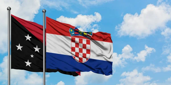 Bandera de Papúa Nueva Guinea y Croacia ondeando en el viento contra el cielo azul nublado blanco juntos. Concepto diplomático, relaciones internacionales . — Foto de Stock