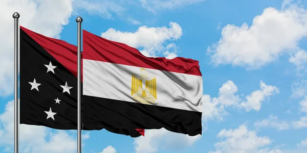 Papua Nova Guiné e a bandeira do Egito agitando no vento contra o céu azul nublado branco juntos. Conceito de diplomacia, relações internacionais . — Fotografia de Stock