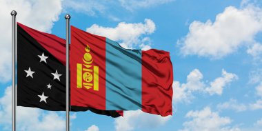 Papua Yeni Gine ve Moğolistan bayrağı birlikte beyaz bulutlu mavi gökyüzüne karşı rüzgarda sallayarak. Diplomasi kavramı, uluslararası ilişkiler.