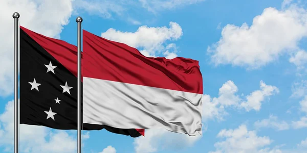 Pápua Új-Guinea és Indonézia zászló integetett a szél ellen, fehér felhős kék ég együtt. Diplomáciai koncepció, nemzetközi kapcsolatok. — Stock Fotó