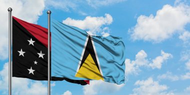 Papua Yeni Gine ve Saint Lucia bayrağı birlikte beyaz bulutlu mavi gökyüzüne karşı rüzgarda sallayarak. Diplomasi kavramı, uluslararası ilişkiler.