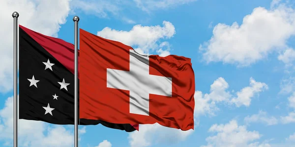 Vlajka Papuy-Nové Guiney a Švýcarska se ve větru vlní proti bíle zatažené modré obloze. Diplomacie, mezinárodní vztahy. — Stock fotografie
