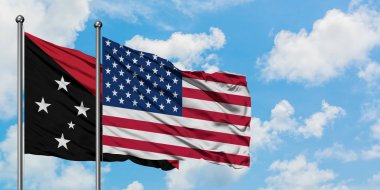 Papua Yeni Gine ve Amerika Birleşik Devletleri bayrağı birlikte beyaz bulutlu mavi gökyüzüne karşı rüzgarda sallayarak. Diplomasi kavramı, uluslararası ilişkiler.