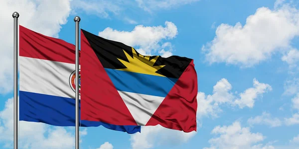Paraguay ve Antigua ve Barbuda bayrağı birlikte beyaz bulutlu mavi gökyüzüne karşı rüzgarda sallayarak. Diplomasi kavramı, uluslararası ilişkiler. — Stok fotoğraf
