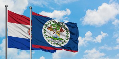 Paraguay ve Belize bayrağı birlikte beyaz bulutlu mavi gökyüzüne karşı rüzgarda sallayarak. Diplomasi kavramı, uluslararası ilişkiler.