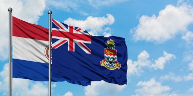 Paraguay ve Cayman Adaları bayrağı birlikte beyaz bulutlu mavi gökyüzüne karşı rüzgarsal sallayarak. Diplomasi kavramı, uluslararası ilişkiler.