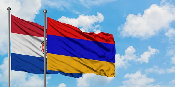 Bandera de Paraguay y Armenia ondeando en el viento contra el cielo azul nublado blanco juntos. Concepto diplomático, relaciones internacionales . — Foto de Stock