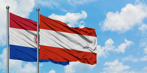 Paragwaj i Austria flaga machając w wiatr przed białym zachmurzone błękitne niebo razem. Koncepcja dyplomacji, stosunki międzynarodowe. — Zdjęcie stockowe