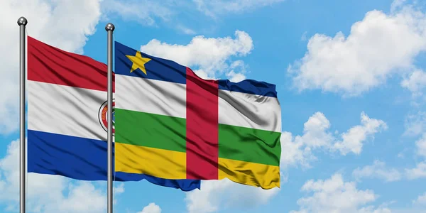 Bandera de Paraguay y República Centroafricana ondeando en el viento contra el cielo azul nublado blanco juntos. Concepto diplomático, relaciones internacionales . — Foto de Stock